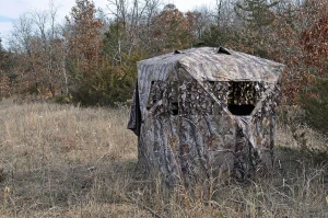 Camouflage pop-up ground blind set up in a grassy field