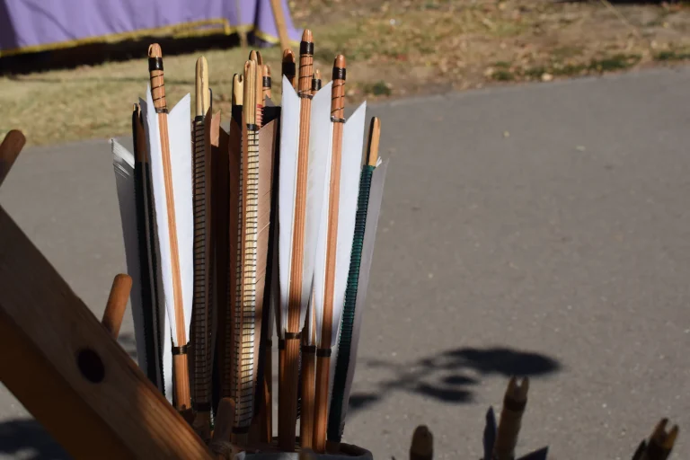 Wooden arrows with feather fletching standing in a quiver